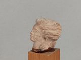 sculpture of a woman ' s head on a wooden base