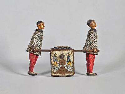 paire de figurines représentant deux hommes avec une boîte posée sur une table