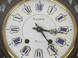 a black clock with gold and blue numbers on it