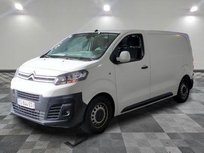 la camionnette blanche est garée dans une grande pièce au sol en damier