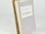 three books stacked on top of each other on a white surface