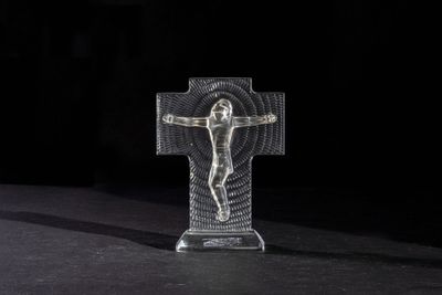 a close up of a cross on a table with a black background