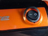 an orange and black camera sitting on a wooden table