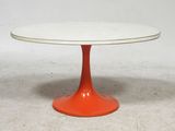 une image représentant une table blanche et orange avec un piètement rouge