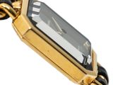 an image of a close up of a wrist watch with a chain around it