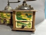 two old fashioned coffee grinders sitting on a table