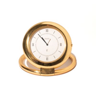 a gold clock with roman numerals on it
