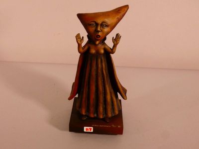 une petite statue représentant une femme coiffée d'un chapeau