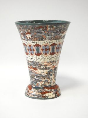 un vase orné d'un motif en mosaïque sur un fond blanc