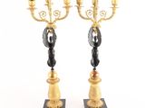 pair of black and gold candelabs on marble bases
