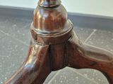 a close up of a wooden table on a tile floor