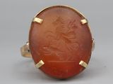 an antique carnel ring with a carved image of a man riding a horse