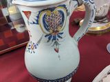 a white vase with a blue and yellow design on it