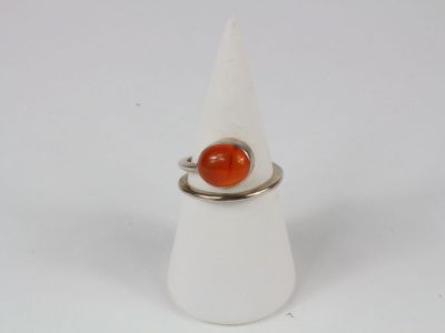 an image of a ring with an orange stone on it