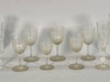 six flûtes à champagne et six verres sont alignés sur une surface blanche
