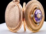 a gold locke with a purple stone inside of it