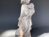 a statue of a boy holding a baby in his arms