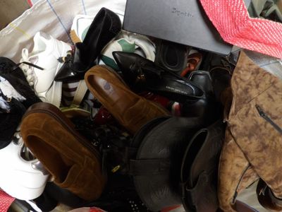 many pairs of shoes in a bag on the floor