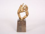 sculpture of two hands holding each other on a marble block