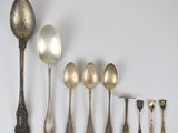 Plusieurs cuillères et cuillères-cuillères sont alignées sur une surface blanche