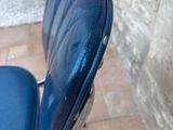 an image of a blue motorcycle seat on a brick floor