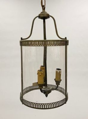 an old fashioned light fixture with two candles inside of it