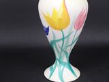 un vase blanc orné de fleurs peintes sur fond noir