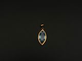 un pendentif en or orné d'une topaze bleue sur fond noir