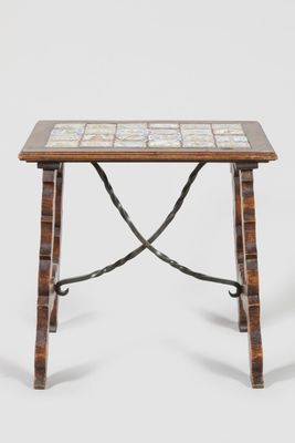 an image of a small table with a tile top and iron legs