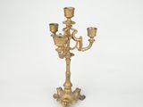 a gold colored candelab with three candles on it
