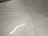 a close up of a car ' s hood with the sun shining on it