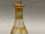an image of a glass bottle with a gold and white design