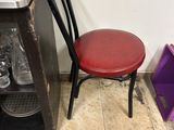 a red chair next to a coffee maker and a purple box