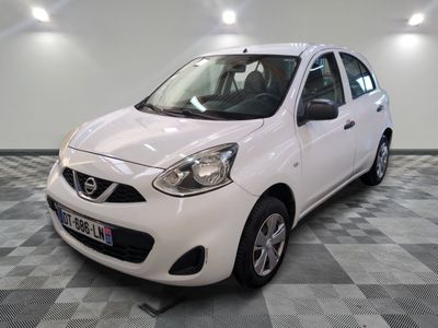 la petite voiture blanche est garée sur un carrelage à carreaux