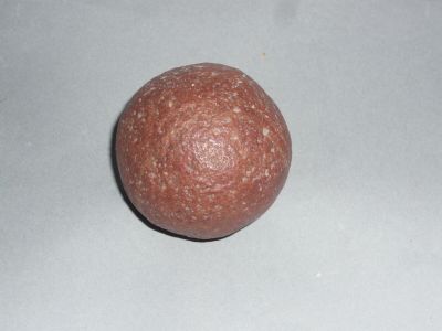 une petite boule orange posée sur une surface blanche