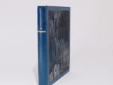 an old blue book sitting on top of a white surface
