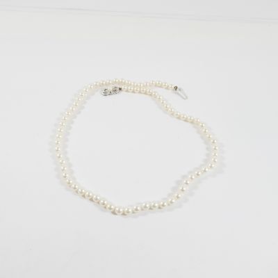 un collier de perles blanches avec un fermoir en argent sur fond blanc