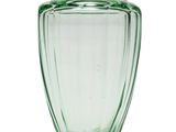 un vase en verre vert posé sur une surface blanche
