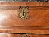 a wooden chest of drawers with a marble top