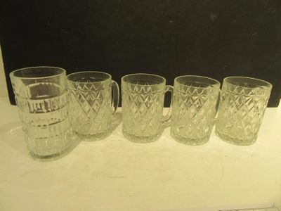 four glasses and a pitcher are lined up on a counter