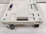 a picture of a white plastic dolly with wheels on a white background