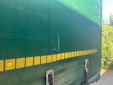 a green and yellow train car parked on the side of the road
