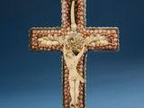 a close up of a cross made out of beads with a person on it