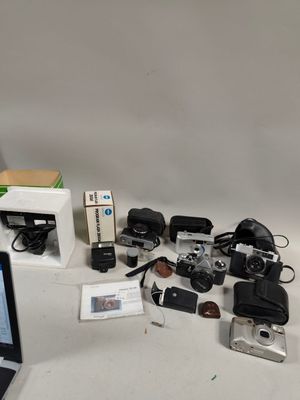 un ordinateur portable posé sur une table à côté d'un appareil photo