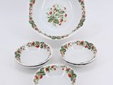 quatre assiettes ornées de motifs de fraises sont disposées sur une surface blanche