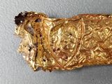 a piece of gold that looks like it has a face on it