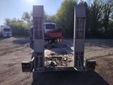 a truck that is parked in a lot with a truck behind it