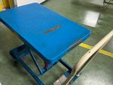 une table bleue sur laquelle repose une batte de baseball, dans un entrepôt