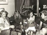 black and white photo of a group of people sitting on a couch