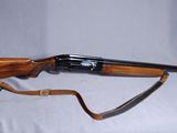 un vieux fusil avec un canon en bois et un étui en cuir